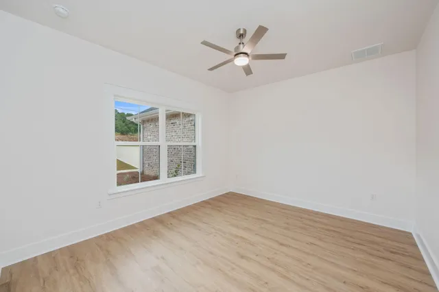 a view of a big room with wooden floor and a ceiling fan