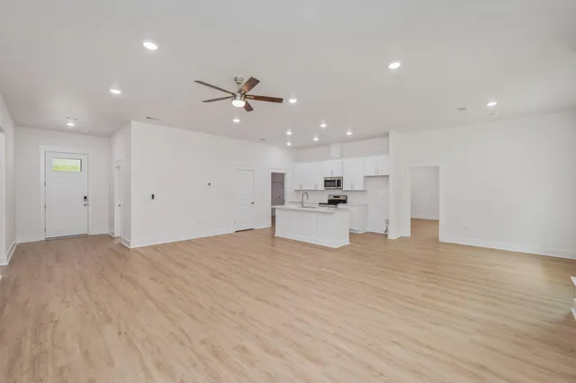 a view of an empty room with a kitchen