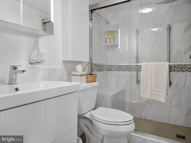 a bathroom with a sink a toilet and shower