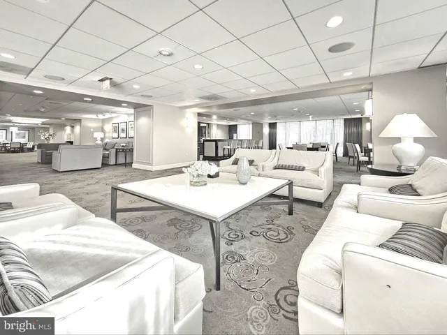 a living room with lots of furniture and view of kitchen
