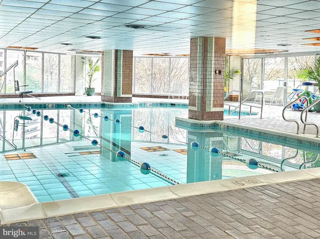 a room with lots of white furniture and a large window