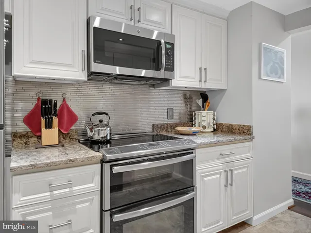 a kitchen with granite countertop cabinets stainless steel appliances and sink
