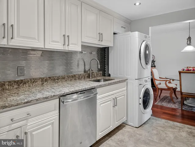 a kitchen with stainless steel appliances granite countertop a sink a stove and white cabinets