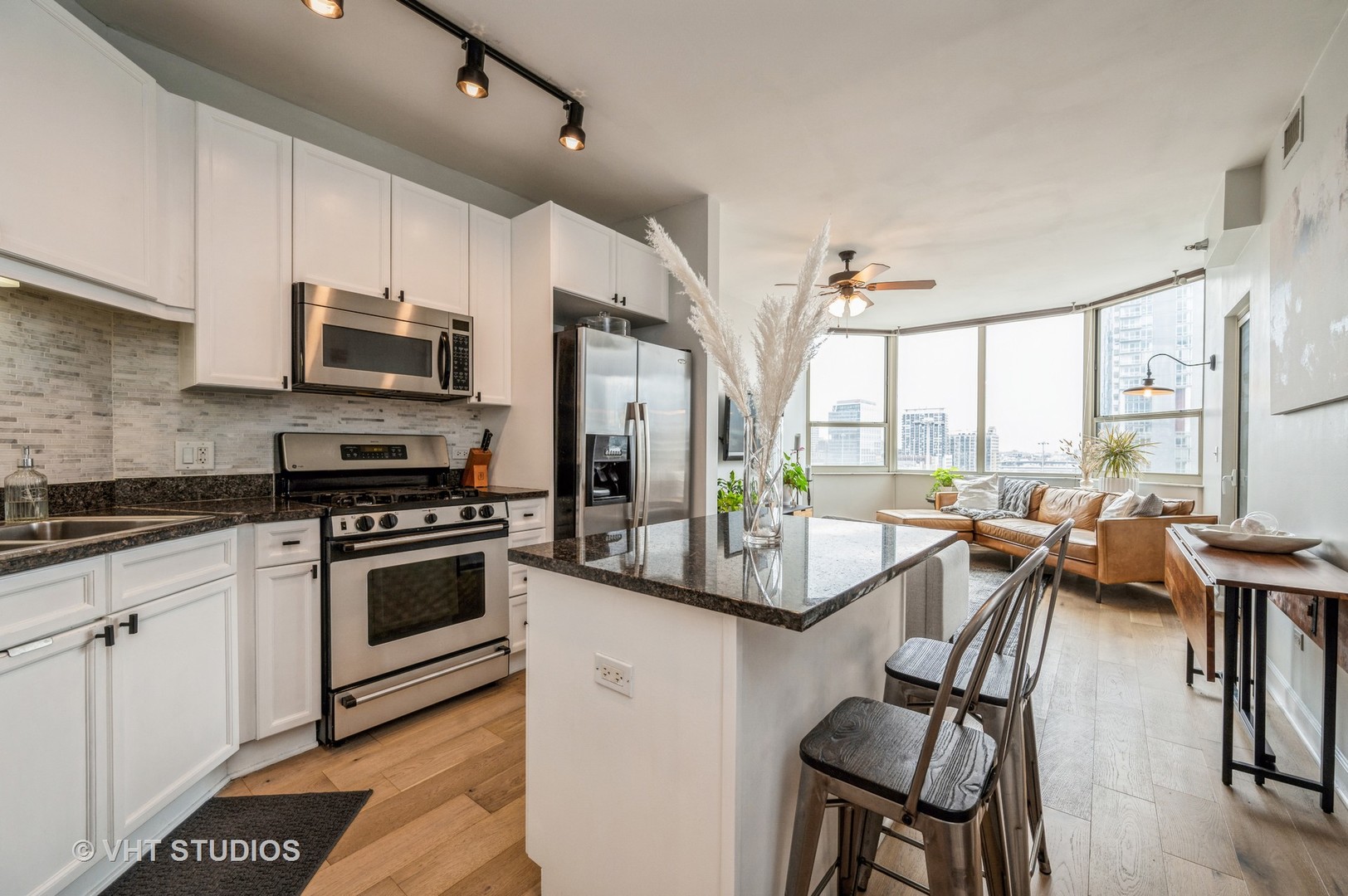 720 West Randolph Street, Unit 1002 Chicago, IL 60661 - Photo 3 of 10 a kitchen with stainless steel appliances granite countertop a stove a sink and a refrigerator