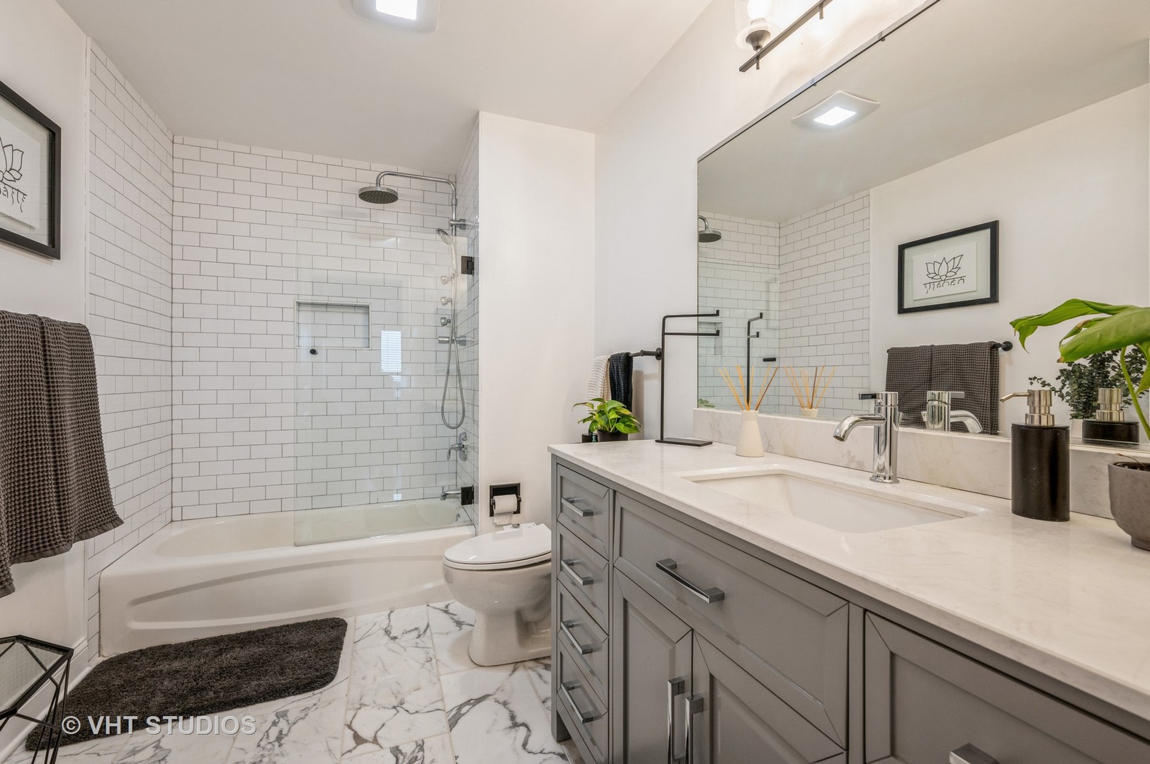720 West Randolph Street, Unit 1002 Chicago, IL 60661 - Photo 6 of 10 a bathroom with a granite countertop bathtub sink vanity mirror and toilet