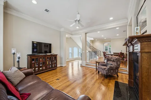 a kitchen with stainless steel appliances granite countertop a stove top oven a sink a dining table and chairs with wooden floor