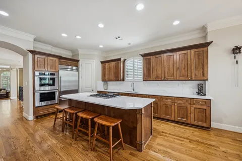 a kitchen with stainless steel appliances granite countertop a sink a refrigerator and cabinets