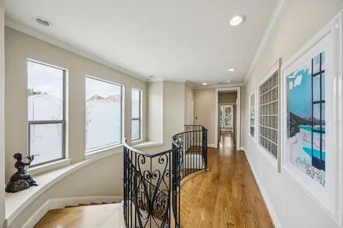 a spacious bedroom with a bed and wooden floor