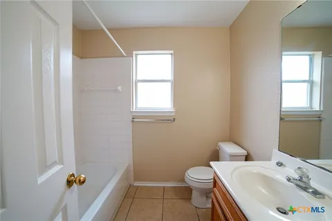 a bathroom with a sink toilet and window