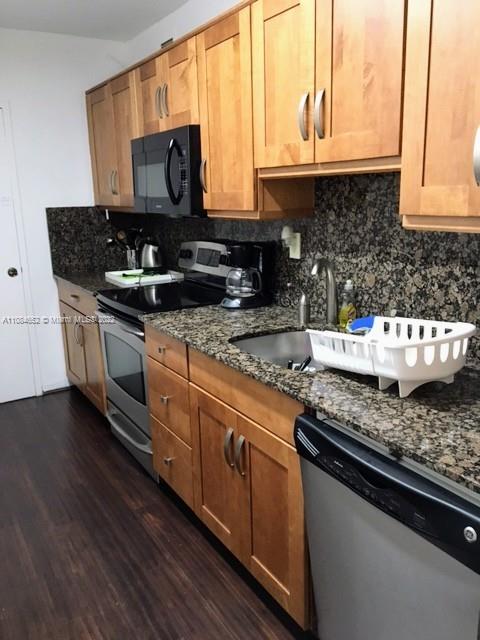 100 Lincoln Road, Unit 637 Miami Beach, FL 33139 - Photo 5 of 13 a kitchen with stainless steel appliances granite countertop a stove a sink and a microwave