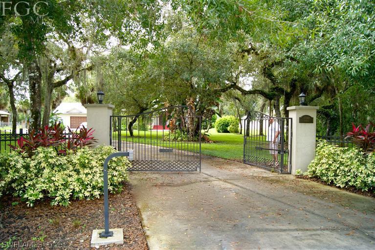 17180 Frank Road Alva, FL 33920 - Photo 1 of 23 a view of a house with a garden and trees