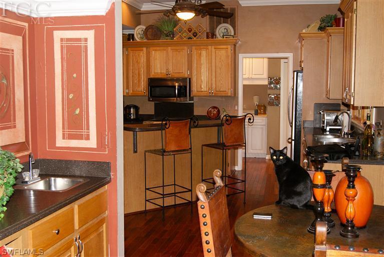 17180 Frank Road Alva, FL 33920 - Photo 13 of 23 a kitchen with stainless steel appliances granite countertop a refrigerator a stove and a sink with wooden floor