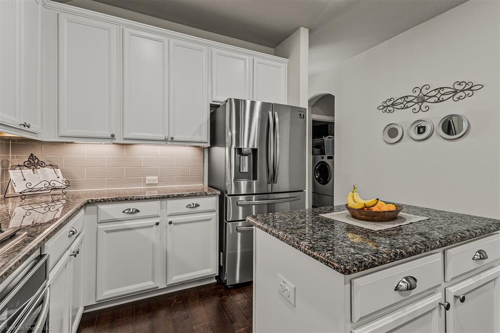 2064 Glaston Road Forney, TX 75126 - Photo 12 of 36 a kitchen with granite countertop stainless steel appliances a refrigerator a stove and white cabinets