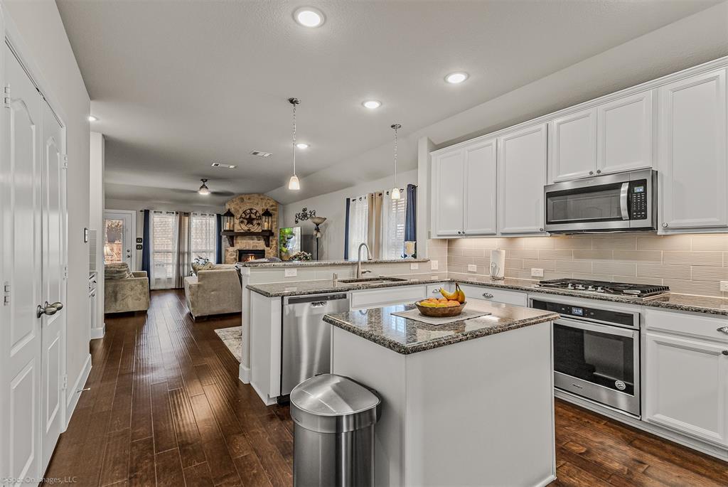 2064 Glaston Road Forney, TX 75126 - Photo 6 of 36 a kitchen with stainless steel appliances granite countertop a stove top oven a sink dishwasher and a refrigerator with wooden floor