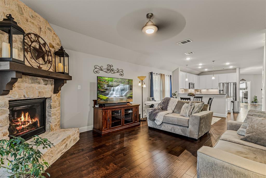 2064 Glaston Road Forney, TX 75126 - Photo 8 of 36 a living room with furniture a fireplace and a kitchen view