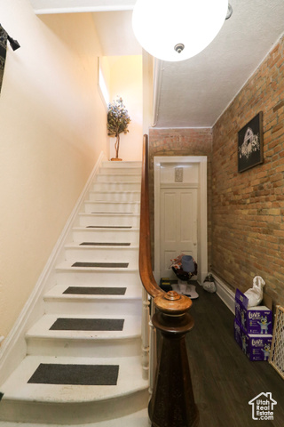 255 27th Street Ogden, UT 84401 - Photo 1 of 1 Staircase featuring wood finished floors and brick wall