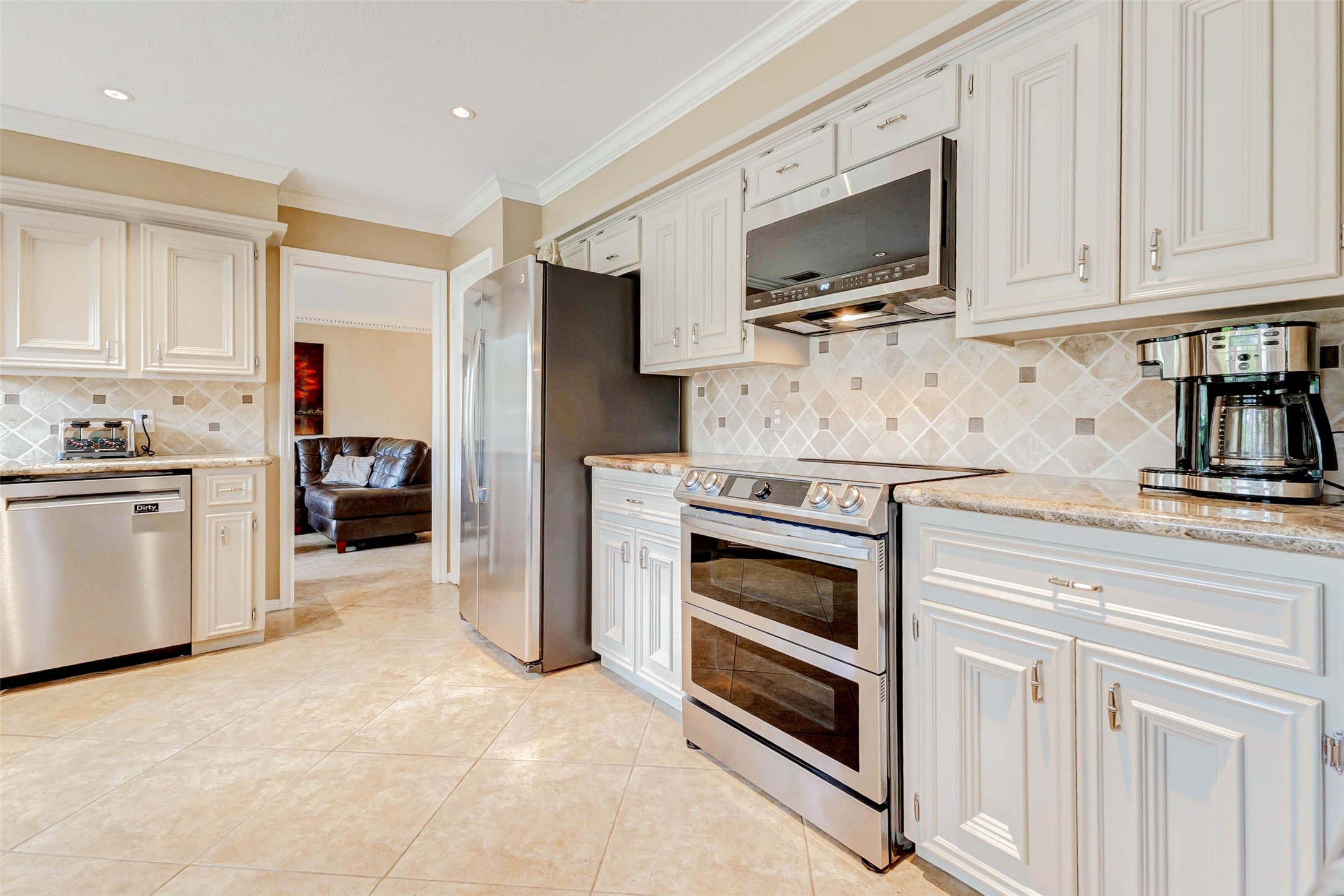 15811 Spring Forest Drive Houston, TX 77059 - Photo 10 of 27 This inviting kitchen boasts elegant cabinetry complemented by sleek stainless steel appliances, creating a modern and welcoming space for culinary adventures.