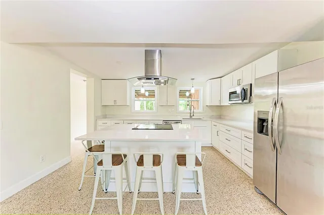 a kitchen with stainless steel appliances a refrigerator and white cabinets