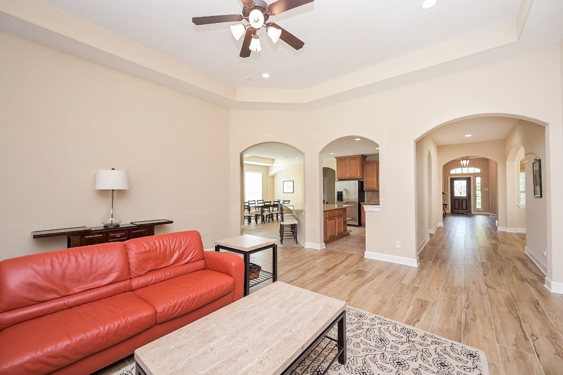 107 North Bacopa Drive Spring, TX 77389 - Photo 11 of 34 Inviting living space with large windows, a ceiling fan, and an open layout that creates an easy flow toward the entry and kitchen.