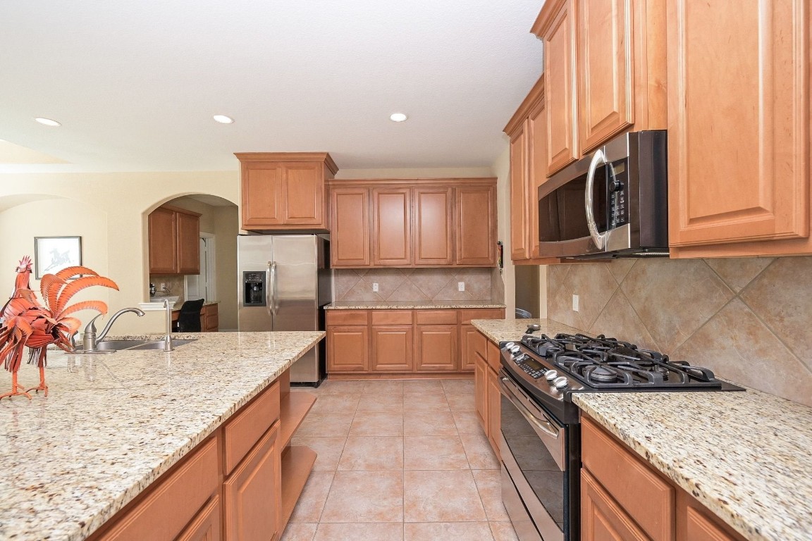 107 North Bacopa Drive Spring, TX 77389 - Photo 16 of 34 Spacious kitchen with abundant cabinet space, recessed lighting, and a large island that opens easily to surrounding living areas for everyday living and entertaining.