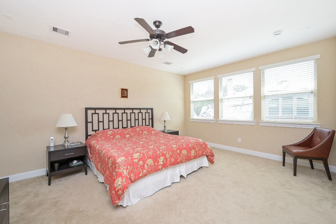 107 North Bacopa Drive Spring, TX 77389 - Photo 25 of 34 Bright bedroom with multiple windows that fill the room with natural light, offering a spacious and inviting setup.