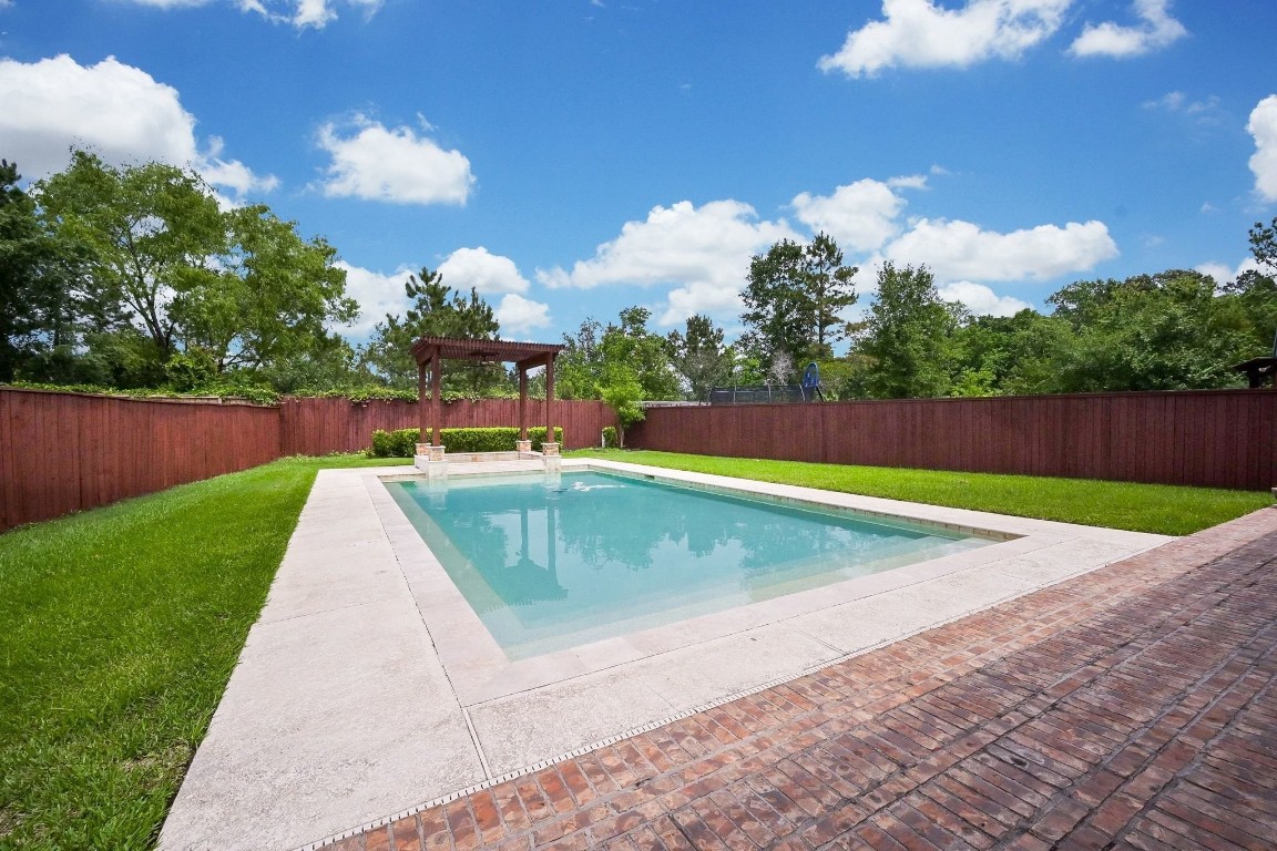 107 North Bacopa Drive Spring, TX 77389 - Photo 30 of 34 Bright and inviting pool area with wide open space and lush surroundings, creating the perfect setting for sunny afternoons and relaxed outdoor living.