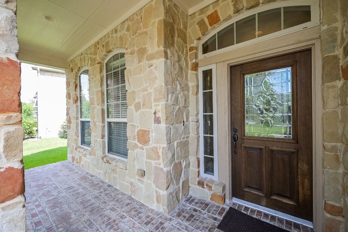 107 North Bacopa Drive Spring, TX 77389 - Photo 3 of 34 Covered front porch with arched windows and natural light, offering a cozy and inviting entry.