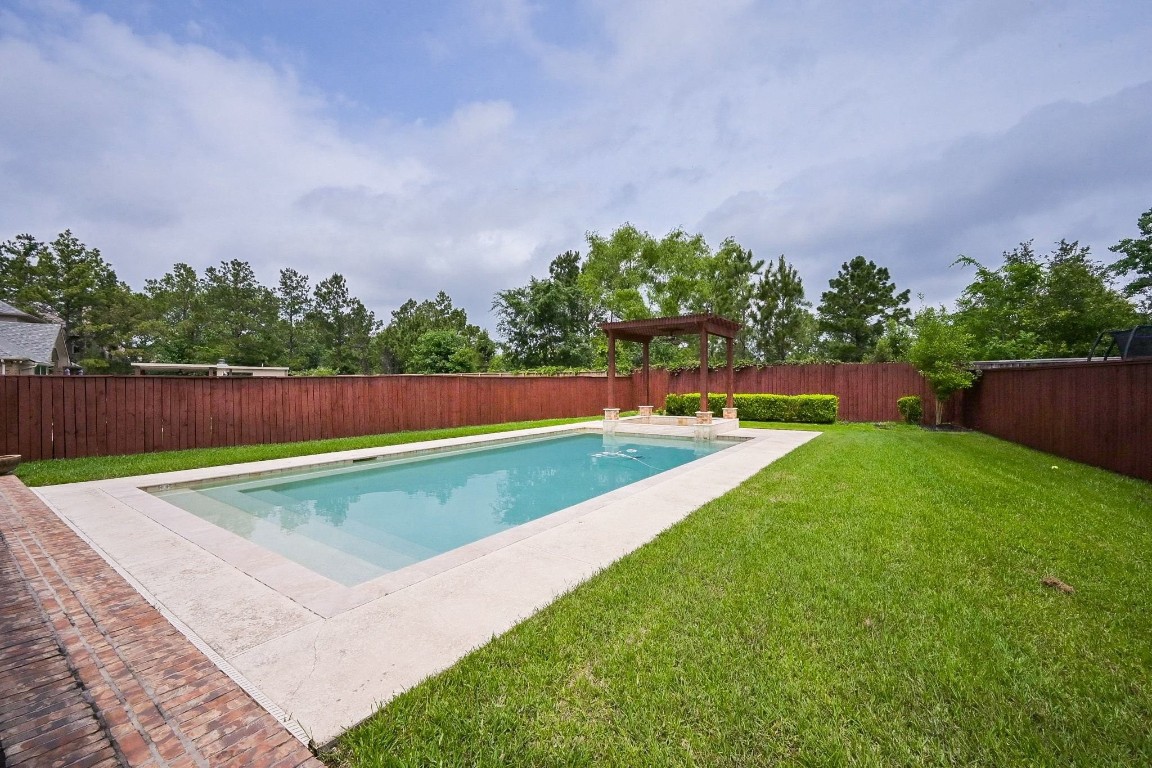 107 North Bacopa Drive Spring, TX 77389 - Photo 32 of 34 Spacious backyard with a beautifully positioned pool and plenty of room to enjoy outdoor living and gatherings.