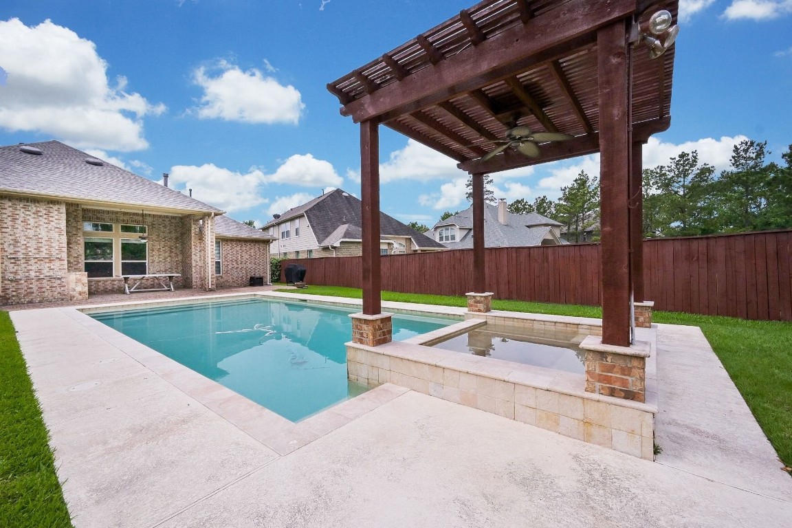 107 North Bacopa Drive Spring, TX 77389 - Photo 33 of 34 Charming pergola overlooking the pool, offering a shaded spot to unwind and enjoy the serene backyard.