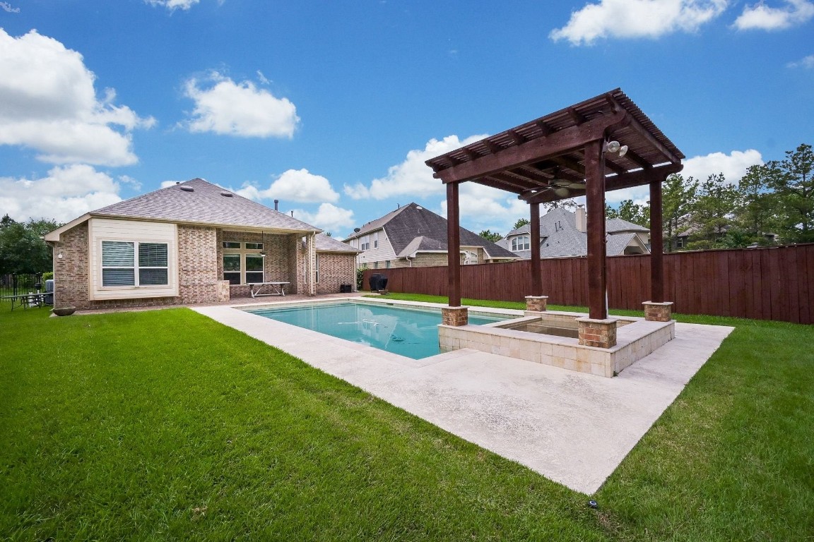 107 North Bacopa Drive Spring, TX 77389 - Photo 34 of 34 Expansive backyard retreat with pool and pergola, designed for easy outdoor living and a seamless connection to the home.