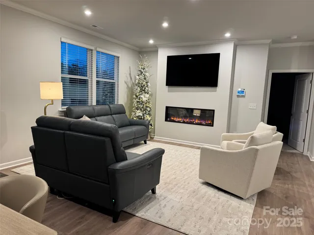 a living room with furniture a fireplace and a flat screen tv