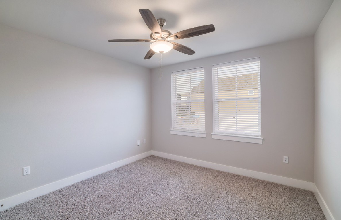 7607 Eckington Street, Unit 235 Austin, TX 78744 - Photo 22 of 37 an empty room with window and ceiling fan