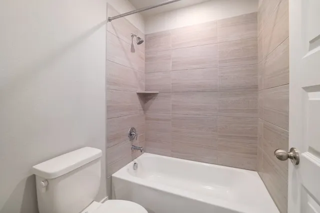 a white bath tub sitting next to a white toilet and sink