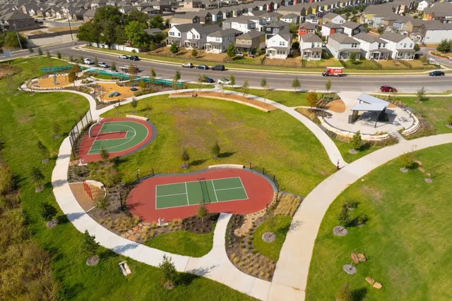 an aerial view of a swimming pool with outdoor seating and yard in back