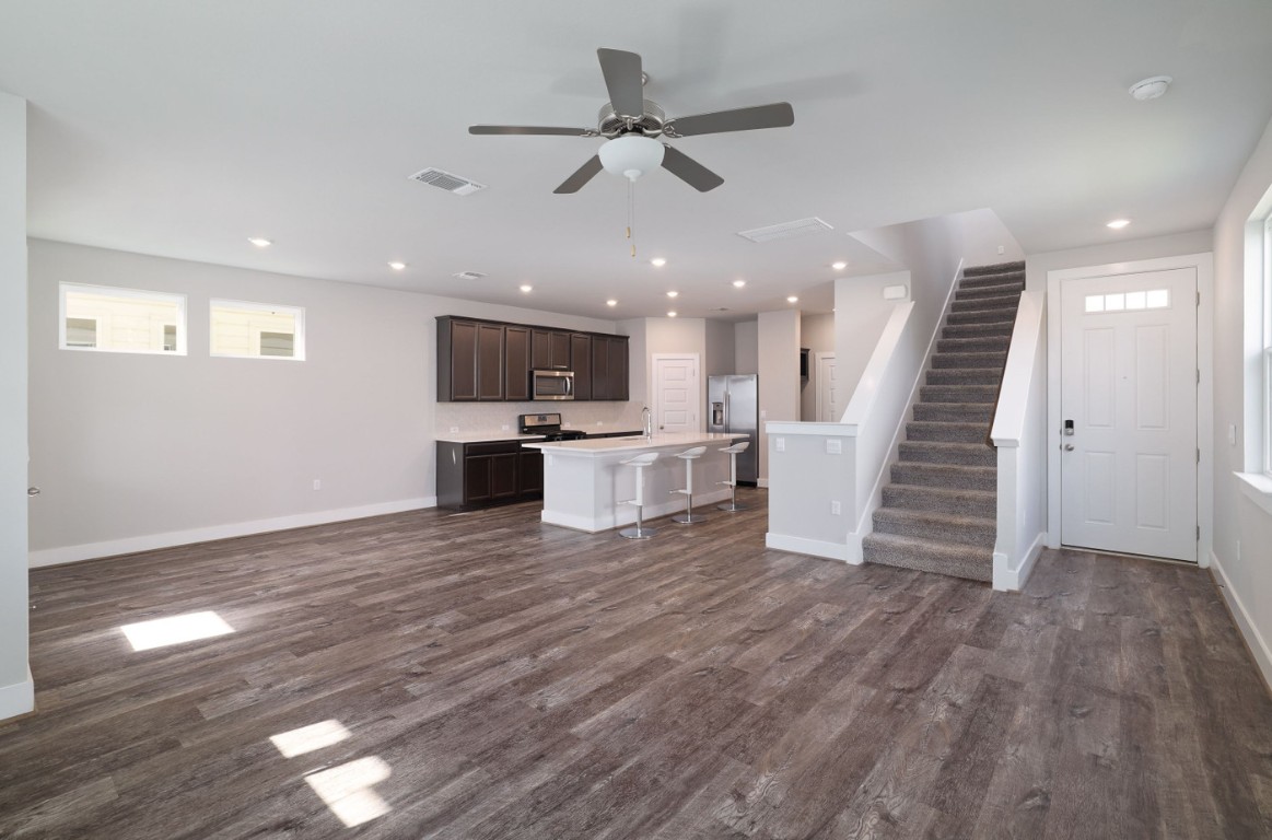 7607 Eckington Street, Unit 235 Austin, TX 78744 - Photo 5 of 37 a view of a livingroom with hardwood floor and a ceiling fan