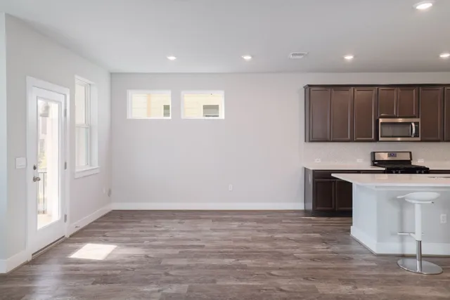 a view of kitchen with granite countertop cabinets and black stainless steel appliances