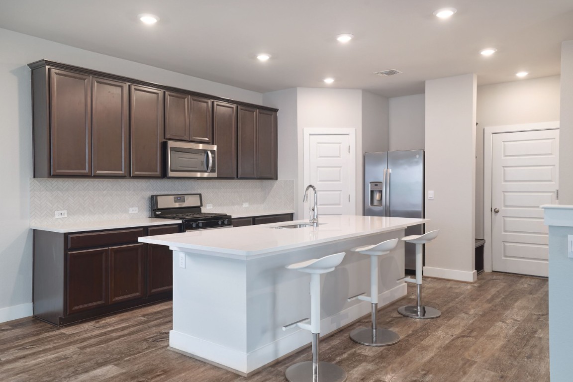 7607 Eckington Street, Unit 235 Austin, TX 78744 - Photo 8 of 37 a kitchen with stainless steel appliances granite countertop a stove a sink a refrigerator and a microwave