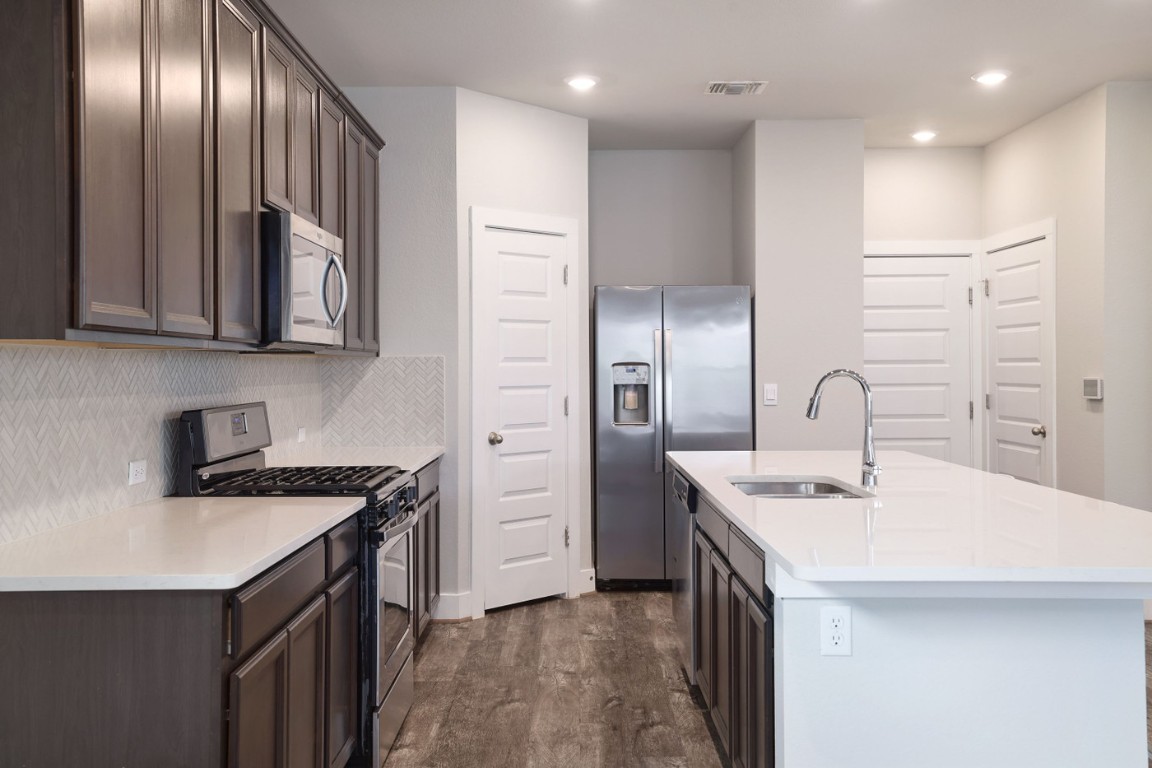 7607 Eckington Street, Unit 235 Austin, TX 78744 - Photo 9 of 37 a kitchen with stainless steel appliances granite countertop a sink a stove and a refrigerator
