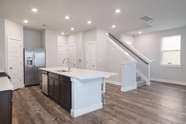 a kitchen with kitchen island a sink and a stove top oven