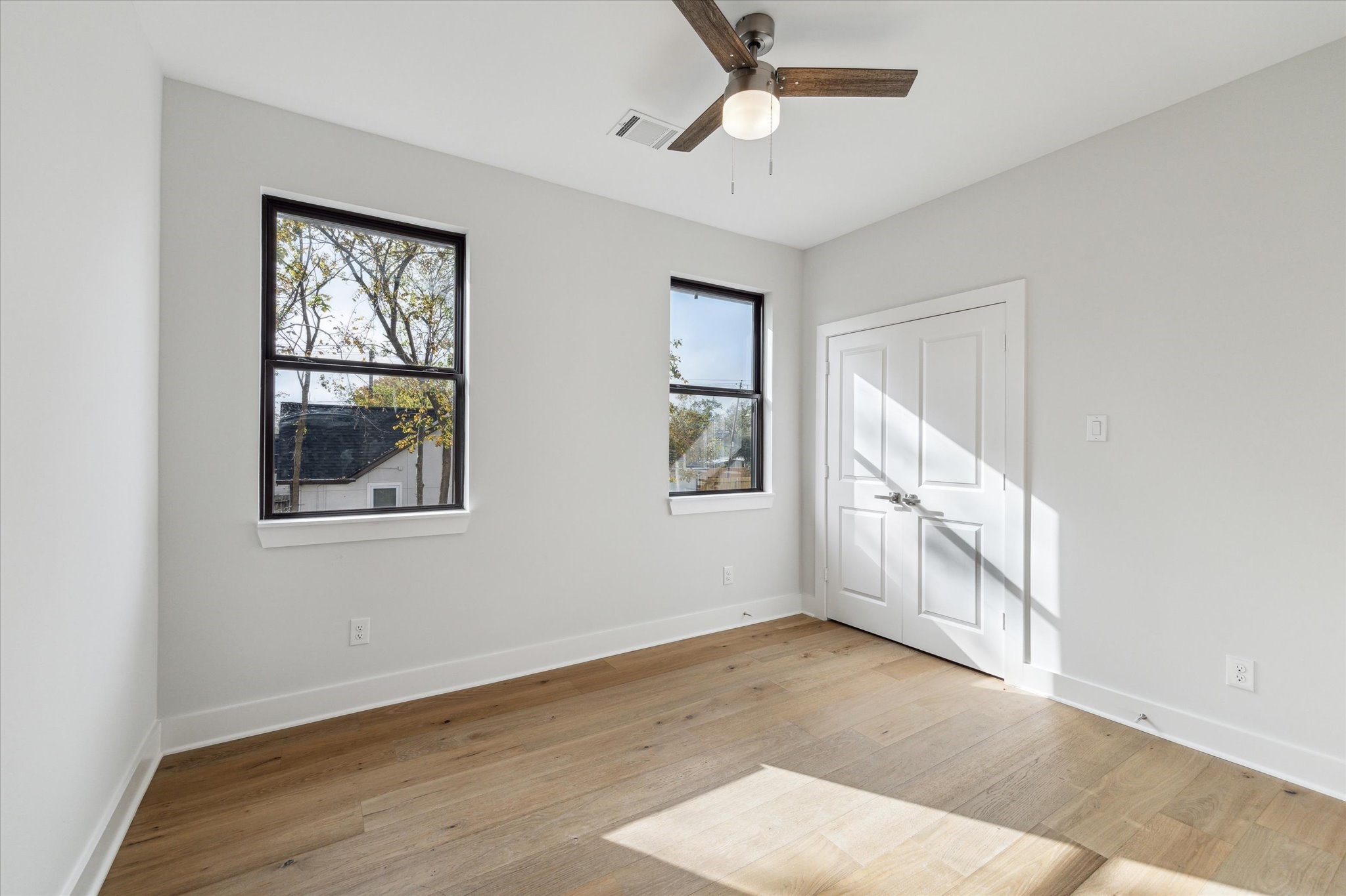 2207 Stevens Street Houston, TX 77026 - Photo 19 of 30 a view of an empty room with a window and wooden floor