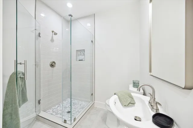 a bathroom with a shower sink and mirror