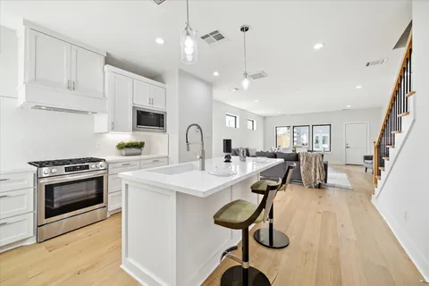 a kitchen with counter top space a sink stainless steel appliances and cabinets