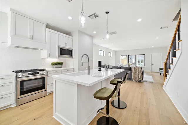 a kitchen with counter top space a sink stainless steel appliances and cabinets