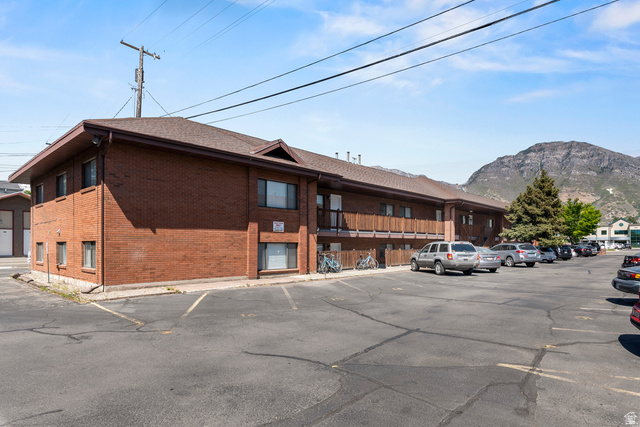 865 North 500 West, Unit 5 Provo, UT 84604 - Photo 12 of 14 Brick multi-story building featuring multiple windows, a brown shingle roof, and a ground-floor patio