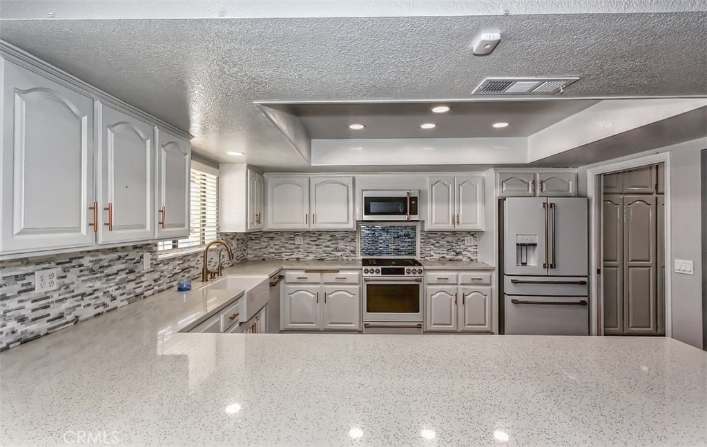 a large kitchen with stainless steel appliances granite countertop a sink window and stainless steel appliances