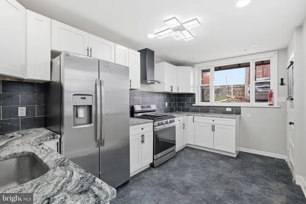 a kitchen with stainless steel appliances granite countertop a sink a stove a refrigerator and island