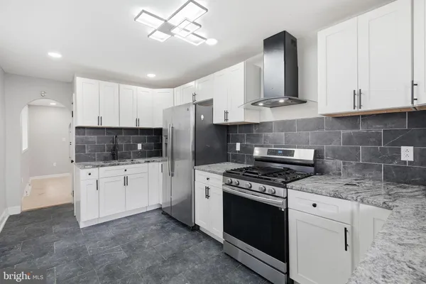 a kitchen with white cabinets stainless steel appliances and sink