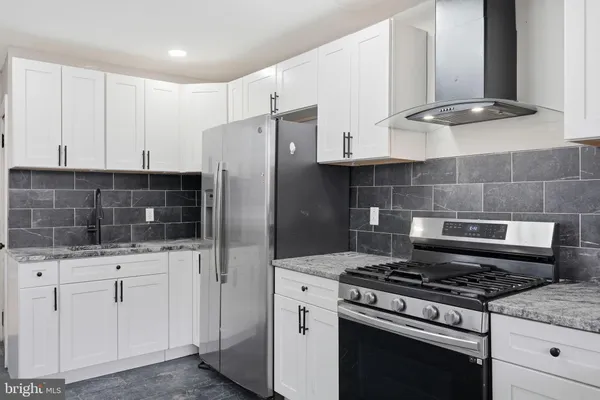 a kitchen with white cabinets and appliances
