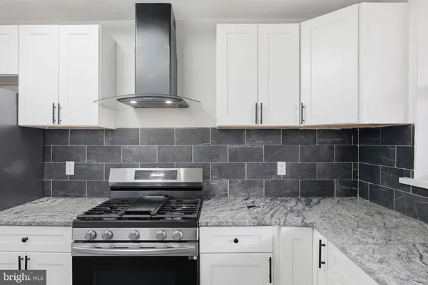 a kitchen with granite countertop a stove sink and cabinets