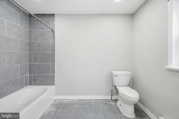 a bathroom with a toilet and bathtub